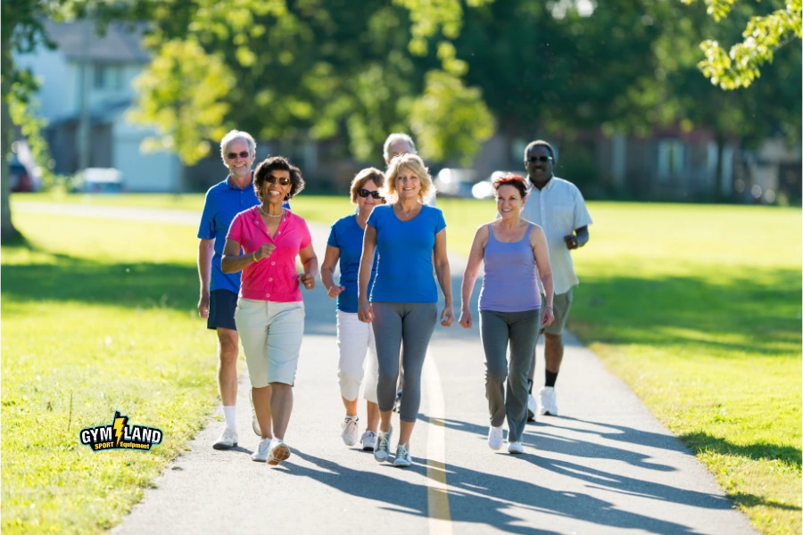 گروه کوچکی از دوستان با میانگین سنی 70 سال در نژادهای گوناگون در حال پیاده روی شادمانه با یکدیگر هستند.